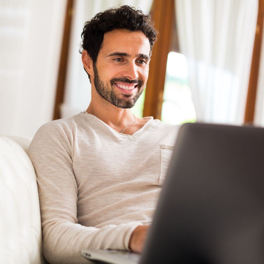 Man happy to see his improved credit score on his laptop